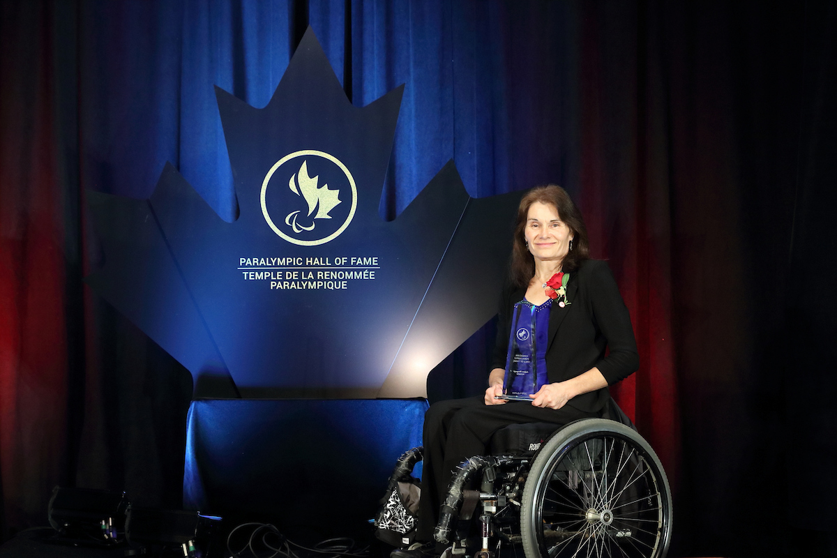 Colette Bourgonje on stage with her induction trophy at the 2019 Canadian Paralympic Hall of Fame Induction Ceremony. 