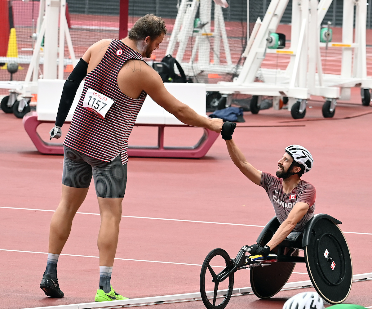Greg Stewart and his para-athletics teammate Brent Lakatos shake hands on the track at the Tokyo 2020 Paralympic Games