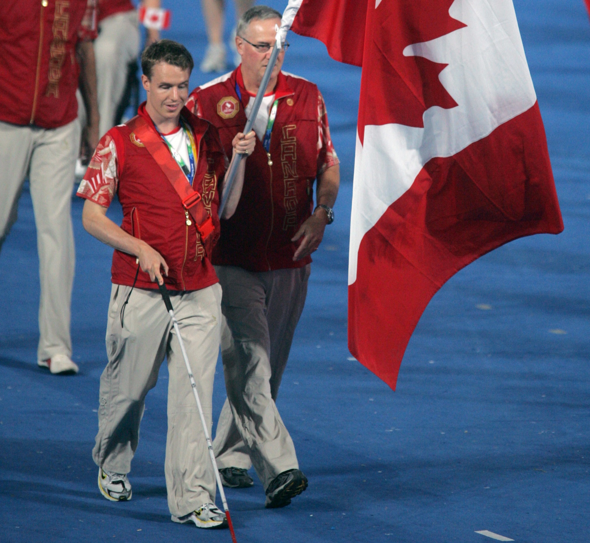 Para swimmer Donovan Tildesley, assisted by his father, waves the flag for Canada at the Opening Ceremony at Beijing 2008. 