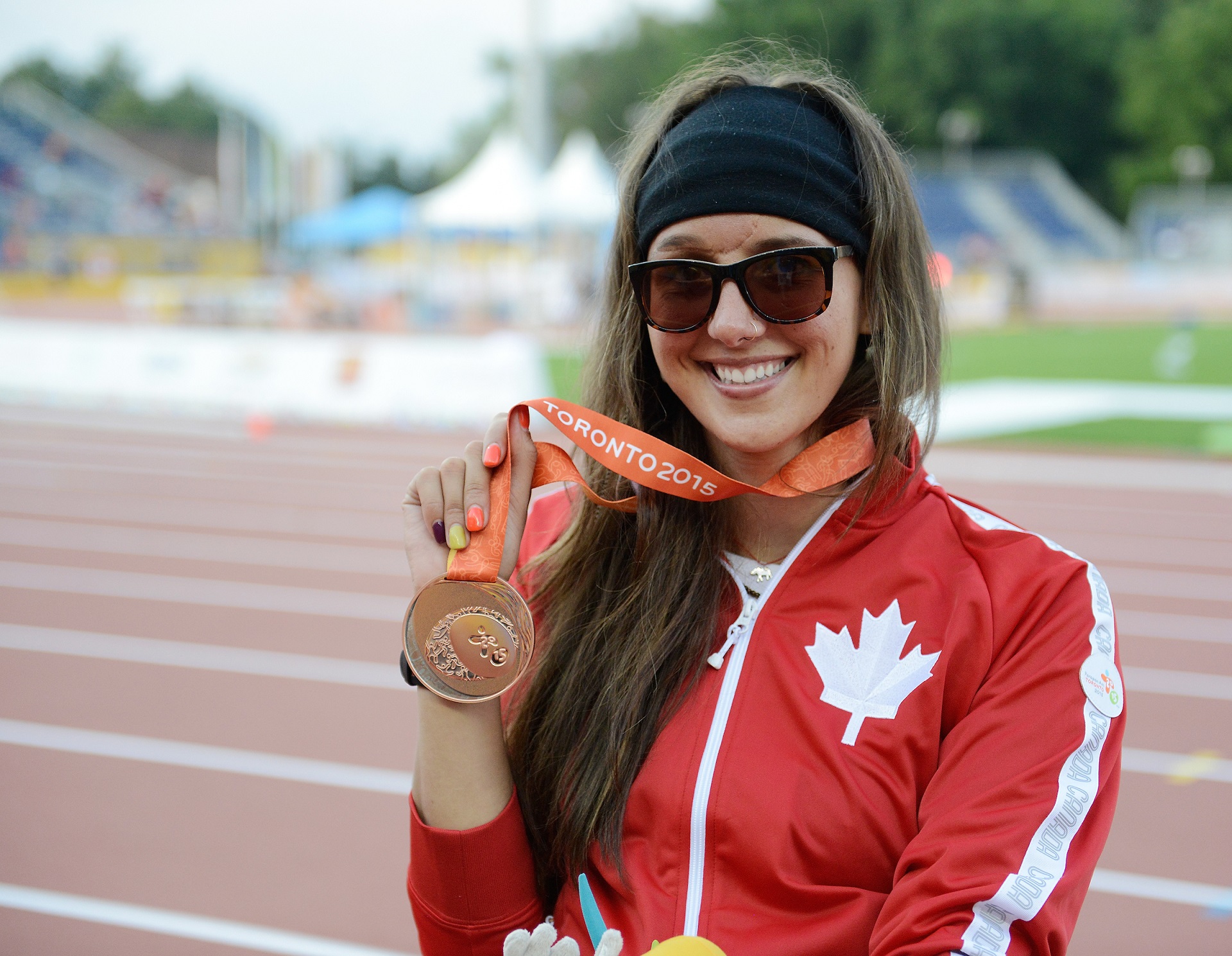 Pam LeJean holding her medal at Toronto 2015
