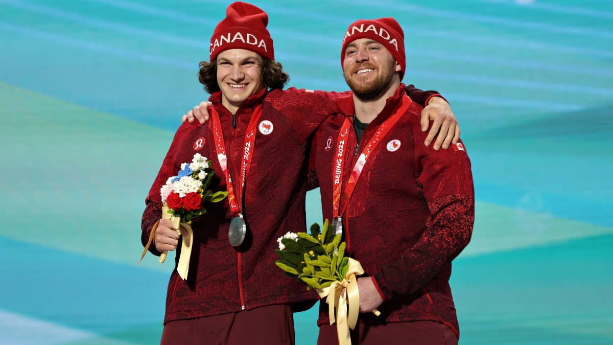 Mac Marcoux and guide Tristan Rodgers with their silver medals on the podium at Beijing 2022