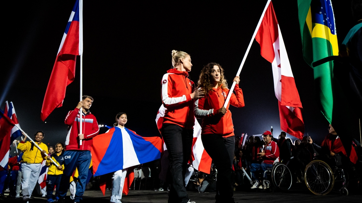 Carla Shibley and pilot Meghan Lemiski carry the flag at the Lima 2019 Closing Ceremony.