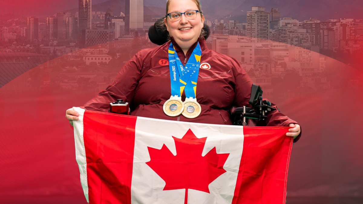 Alison Levine wearing his gold medals, smiling, holding the Canadian flag