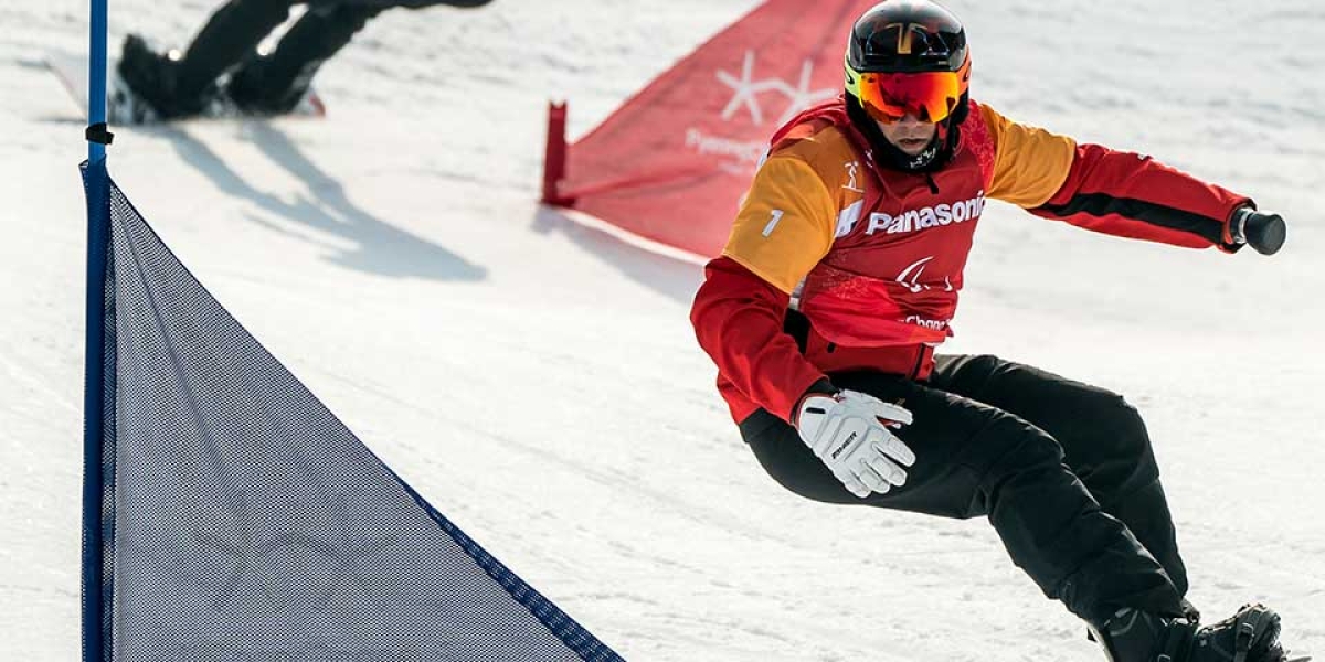 Curt Minard faint around a gate in snowboard cross