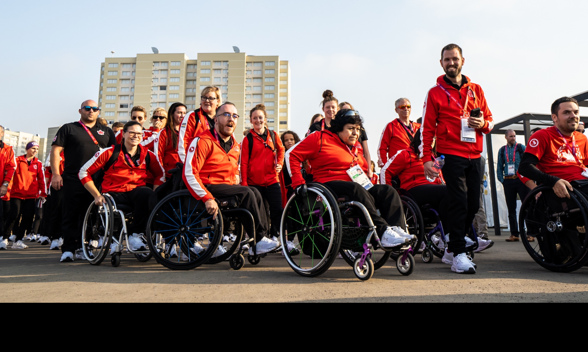 Athletes Walking and Wheeling together in Team Canada red jackets 