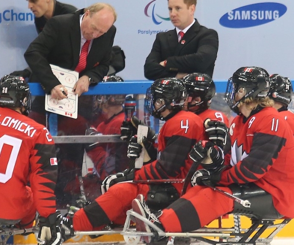 Paralympic hockey team getting advice from their coach.