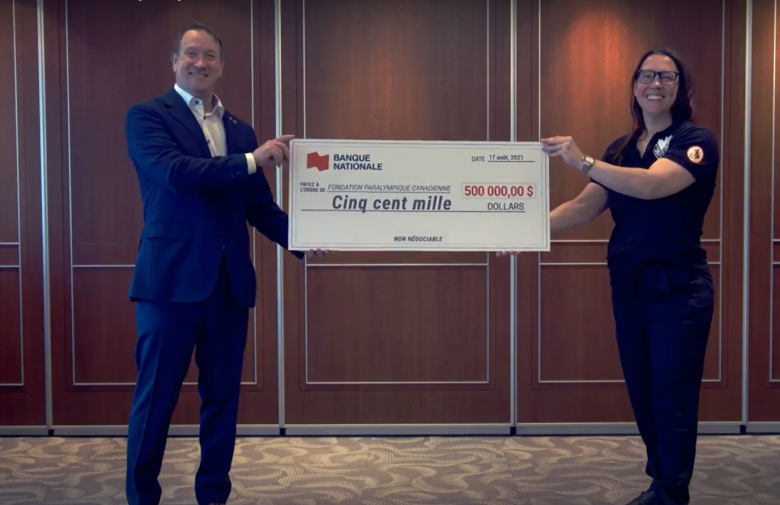 Louis Vachon, president and CEO of National Bank, and Paralympian Karolina Wisniewska hold up a $500,000 cheque in support of the Paralympic Foundation of Canada.