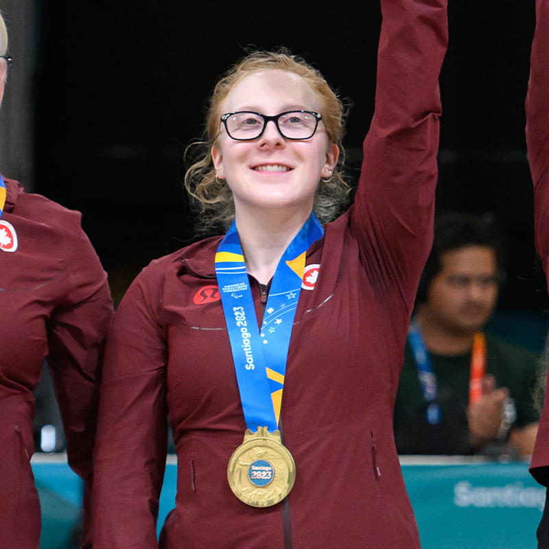 Brieann Baldock wearing a gold medal on the podium at the Santiago 2023 Parapan American Games.