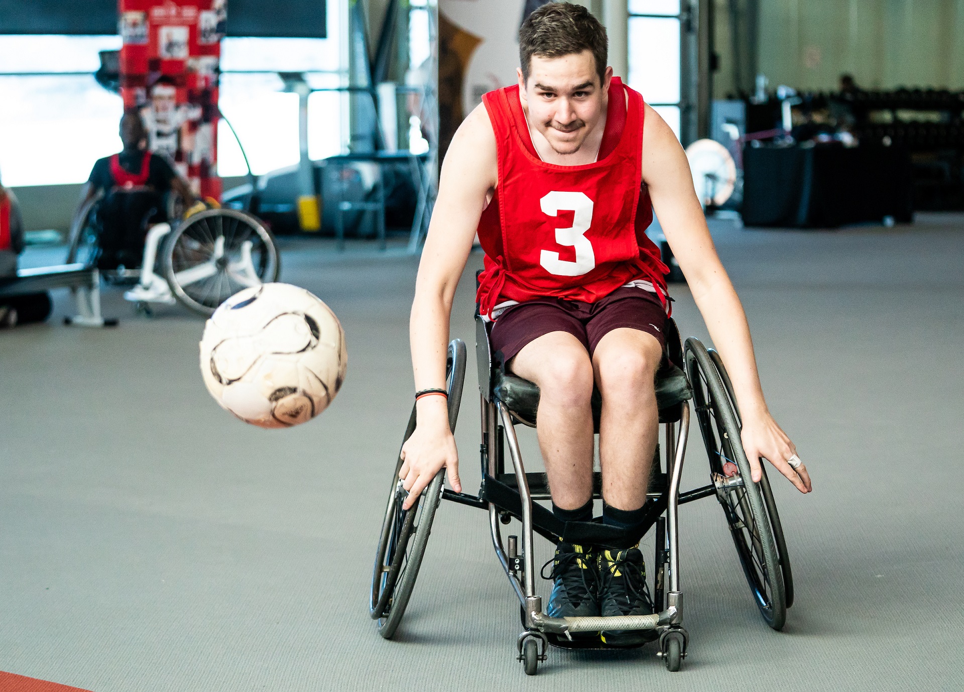 A Paralympian Search participant in a wheelchair races to catch a ball