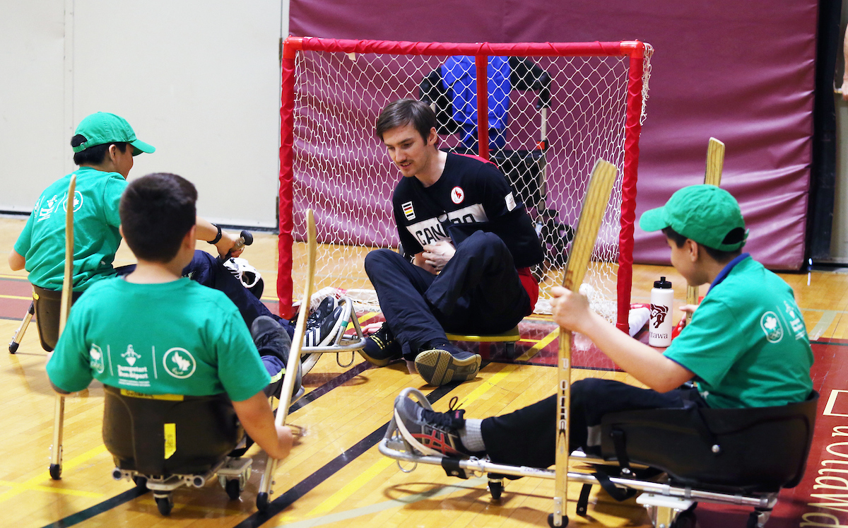 Rob Armstrong and a group of kids try an adapted version of Para ice hockey at a Canadian Tire Jumpstart event in 2018