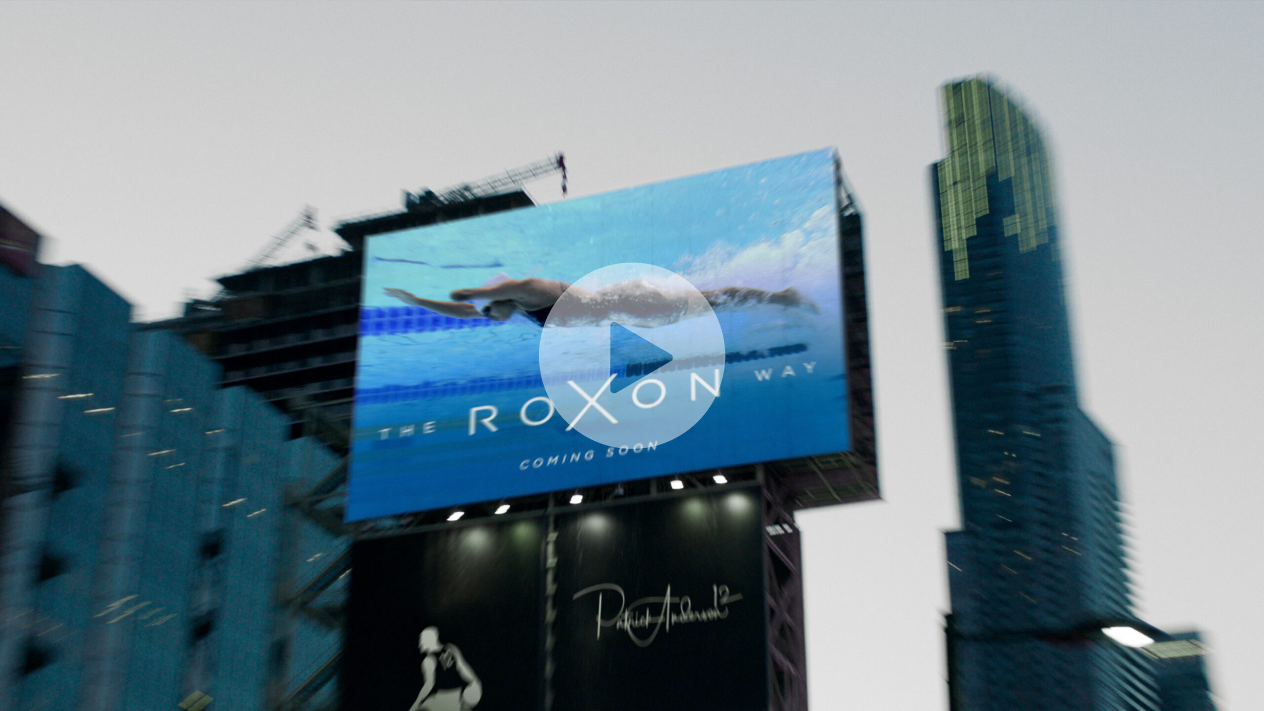 A still from the We're Here" campaign showing a billboard promoting a documentary about Katarina Roxon"