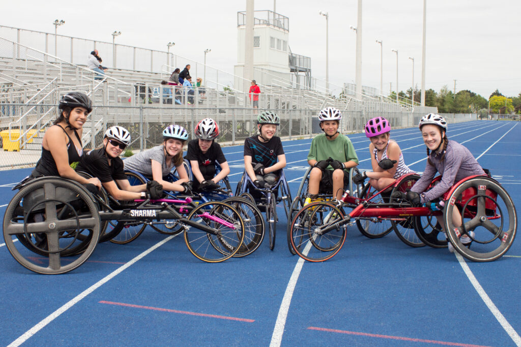 A group of Cruisers wheelchair racers together on the track
