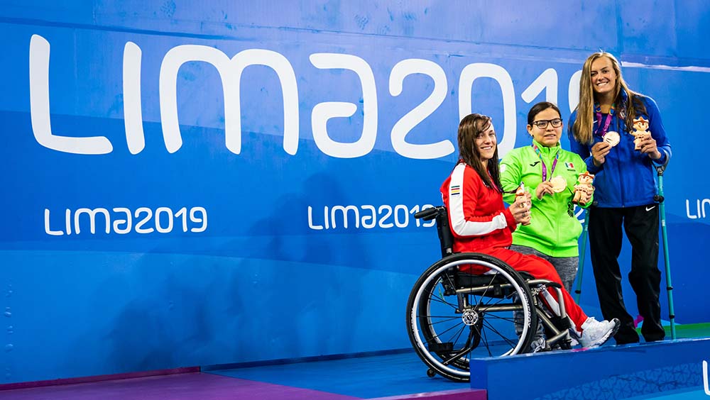 3 medallists together, Lima written on wall behind them