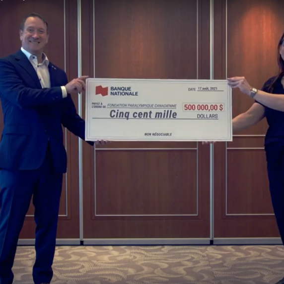 Louis Vachon, president and CEO of National Bank, and Paralympian Karolina Wisniewska hold up a $500,000 cheque in support of the Paralympic Foundation of Canada.