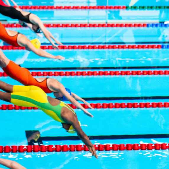 Swimmers diving into a pool at the Santiago 2023 Parapan American Games. | Nageurs plongeant dans une piscine lors des Jeux parapanaméricains de Santiago 2023.