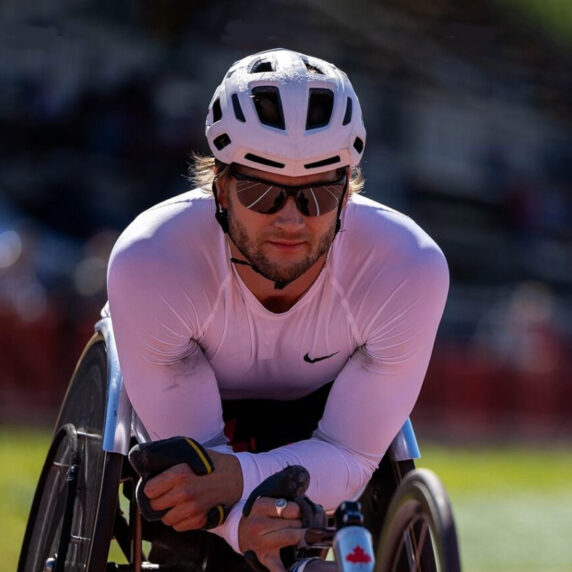 Canadian wheelchair racer Austin Smeenk resting on his racing wheelchair following a race at the 2024 Athletics Canada Paralympics Trials.