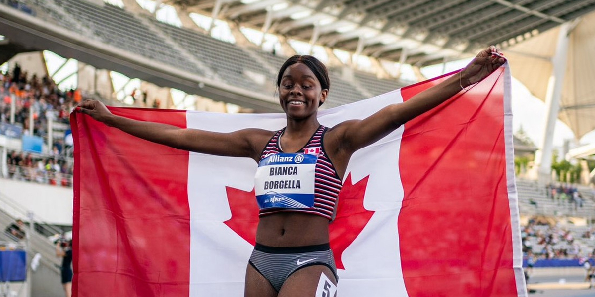 Canadian Para athletics sprinter Bianca Borgella holds aloft the Canadian flag behind her and between her fully outstretched arms after winning silver at the 2023 World Para athletics Championships.