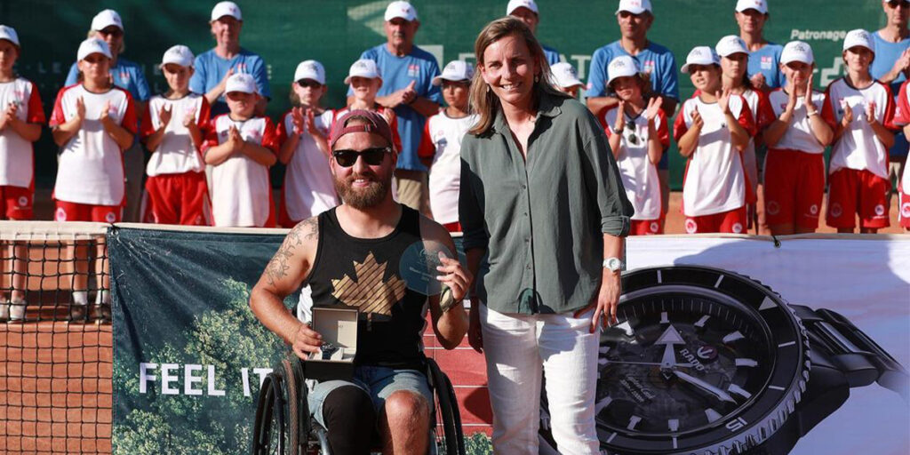 Canadian Wheelchair tennis star Rob Shaw poses with his winner's trophy at the 2024 Swiss Open, standing next to Rob is an official from the tournament.