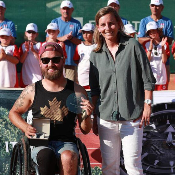 Canadian Wheelchair tennis star Rob Shaw poses with his winner's trophy at the 2024 Swiss Open, standing next to Rob is an official from the tournament.