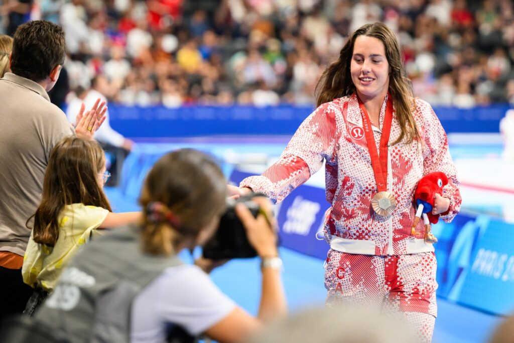 Canadian para swimmer Aurelie Rivard high-fiving fans outside of the pool.