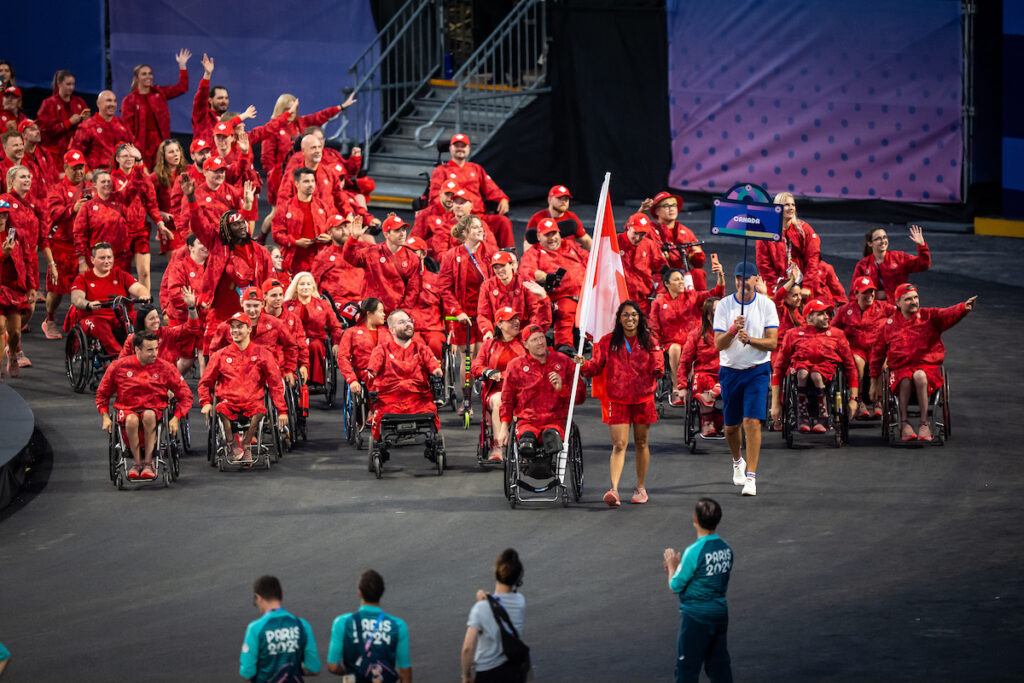 The Canadian Paralympic Team waving to a crowd during the Paris 2024 Paralympic Opening Ceremonies.