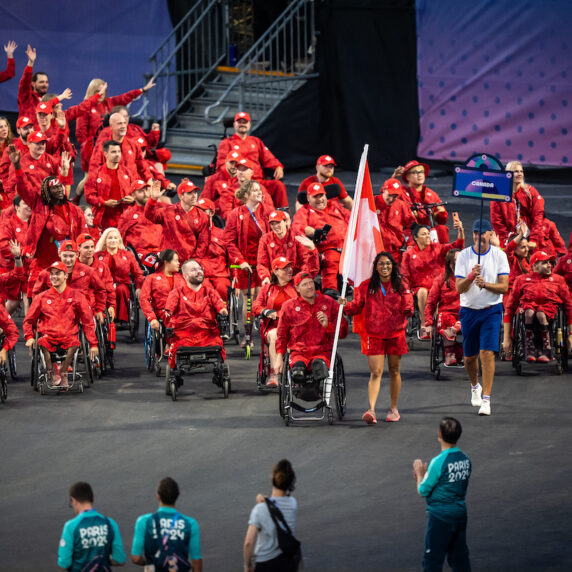 The Canadian Paralympic Team waving to a crowd during the Paris 2024 Paralympic Opening Ceremonies.