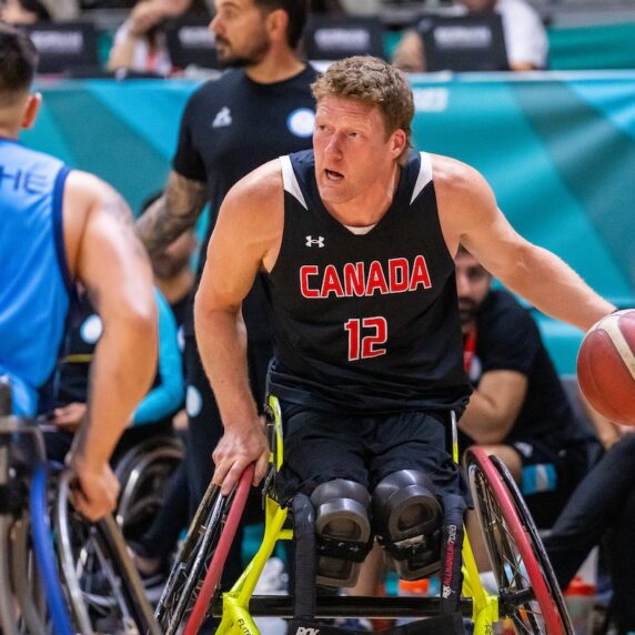 Wheelchair basketball star Patrick Anderson bouncing the ball.