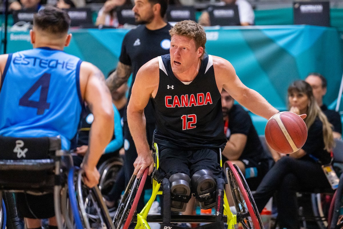 Wheelchair basketball star Patrick Anderson bouncing the ball.