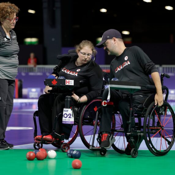 Alison Levine and Iulian Ciobanu discuss strategy in front of a boccia court with balls in play