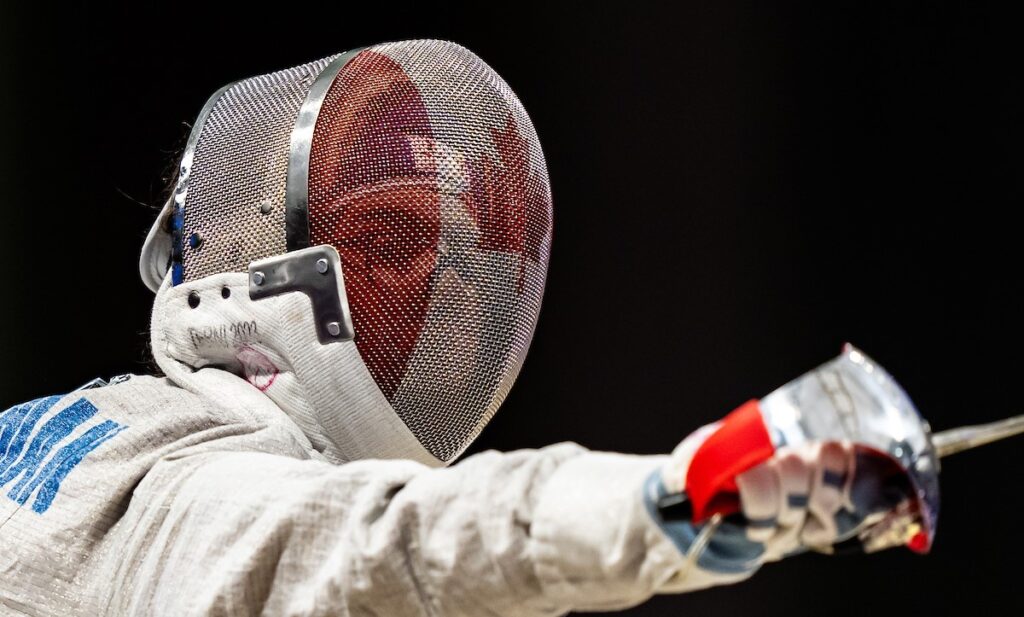 Close up of Trinity Lowthian's face behind her fencing mask