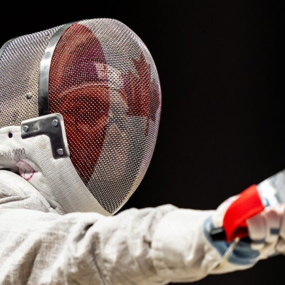 Close up of Trinity Lowthian's face behind her fencing mask