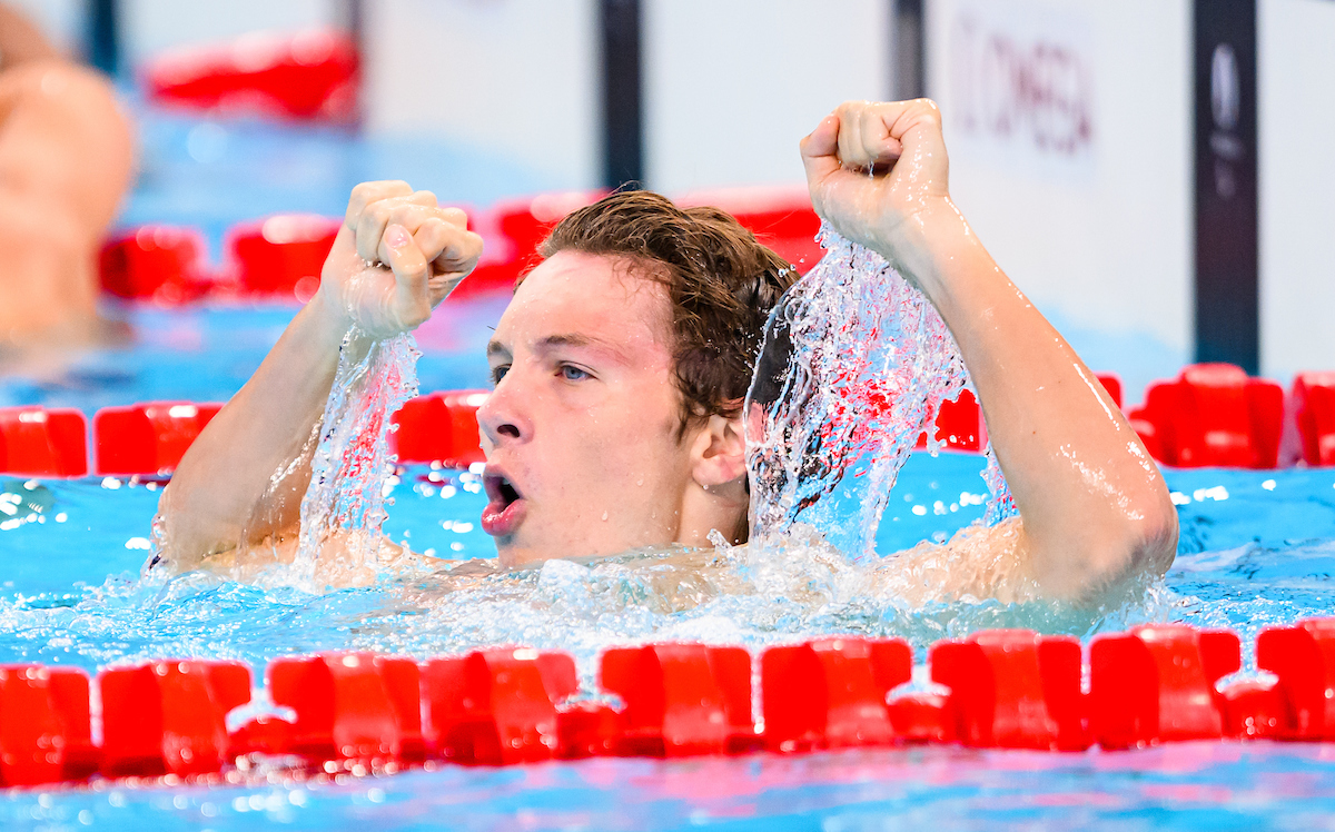 Nicholas Bennett raises his arms in the pool after winning gold.