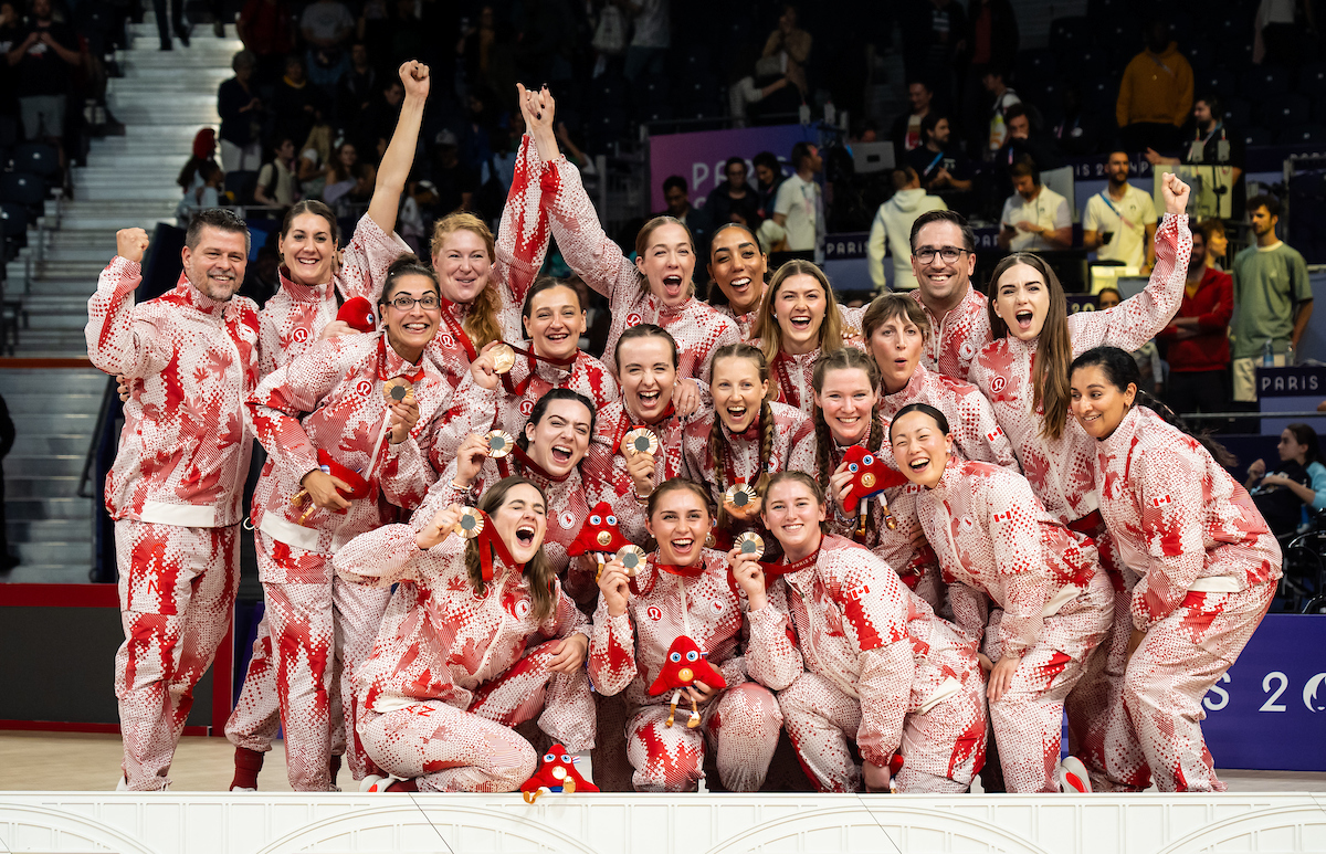 The Canadian Paralympic sitting volleyball team celebrates with their gold medals.