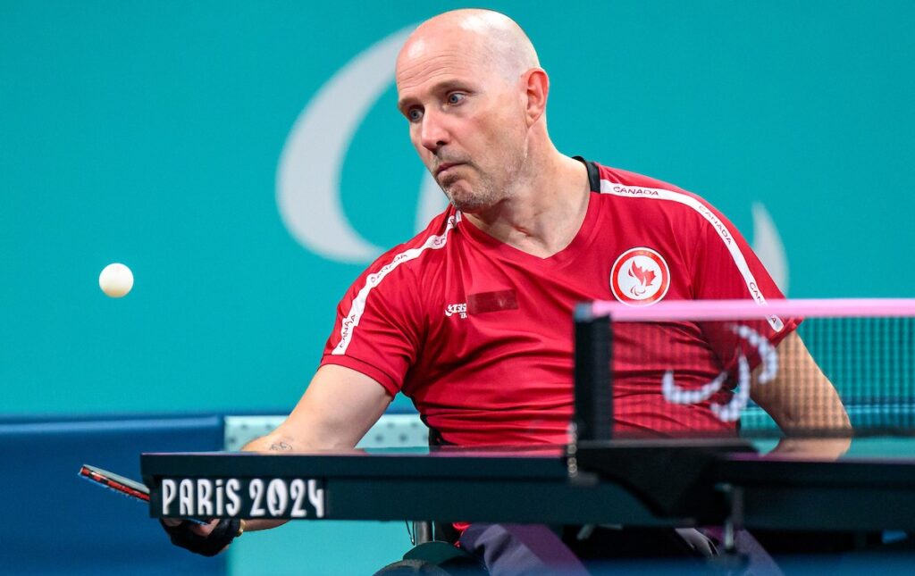 Peter Isherwood bouncing a ping pong ball off his paddle during practice.