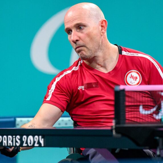 Peter Isherwood bouncing a ping pong ball off his paddle during practice.