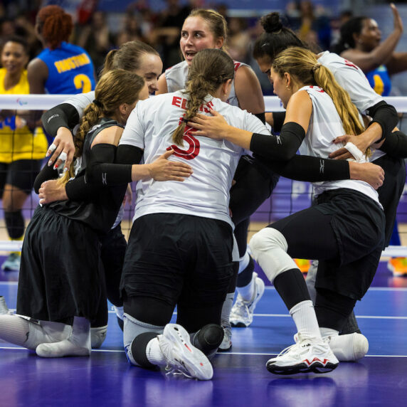 L’équipe canadienne de volleyball assis se fait une accolade après avoir compté un point.