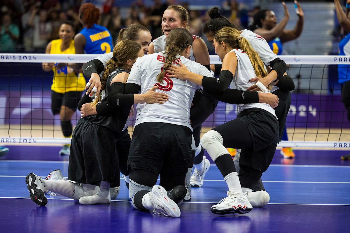 L’équipe canadienne de volleyball assis se fait une accolade après avoir compté un point.