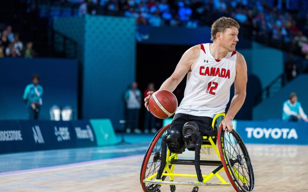 Wheelchair basketball star Patrick Anderson bouncing the ball.
