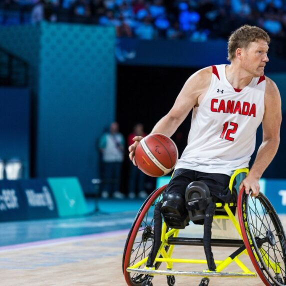 Wheelchair basketball star Patrick Anderson bouncing the ball.