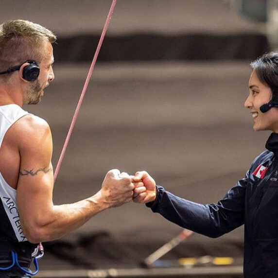 Blind Canadian Para climber Chaz Misuraca fist bumps with his guide Alannah Yip before he begins climbing up the wall.