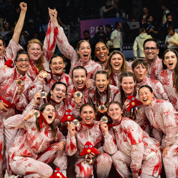 The Canadian women’s sitting volleyball team celebrates winning bronze at the Paris 2024 Paralympics. The team poses together in their red and white patterned uniforms, smiling and proudly holding their bronze medals and Paralympic mascots. Their joy and unity radiate as they commemorate this remarkable achievement on the world stage.