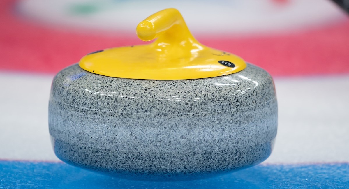 Close up photo of a curling rock on ice