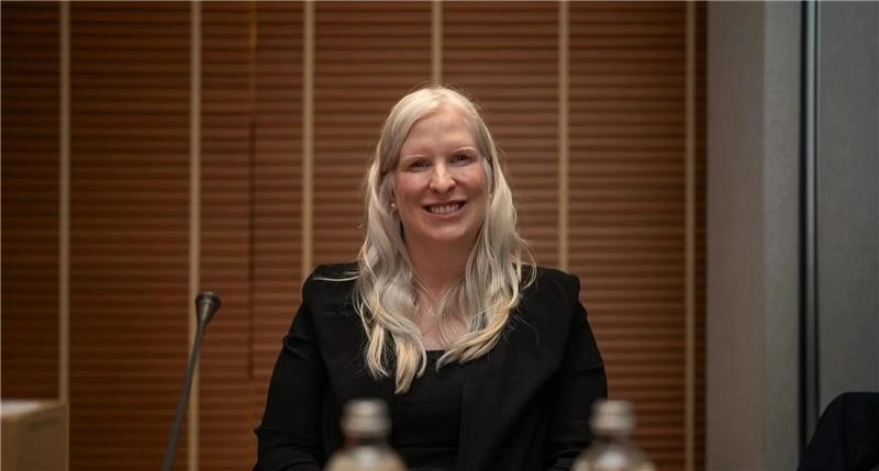 Chelsey Gotell posing sitting down and smiling at the camera