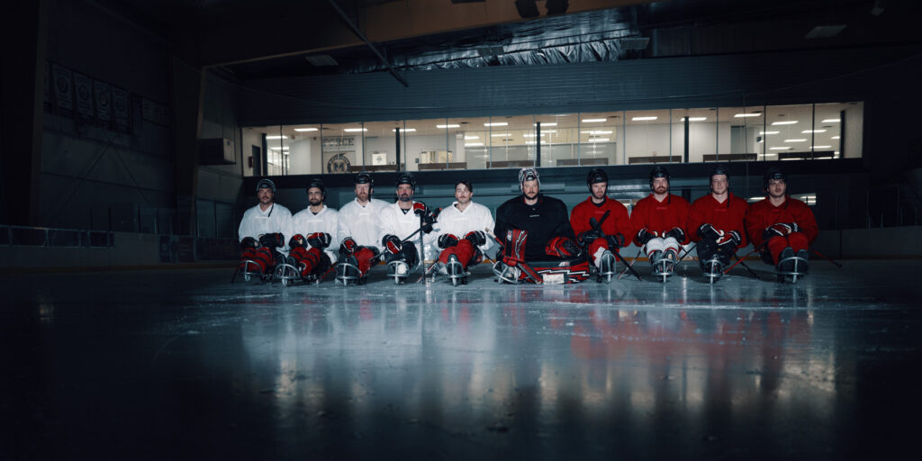 The Para ice hockey team waits on the ice