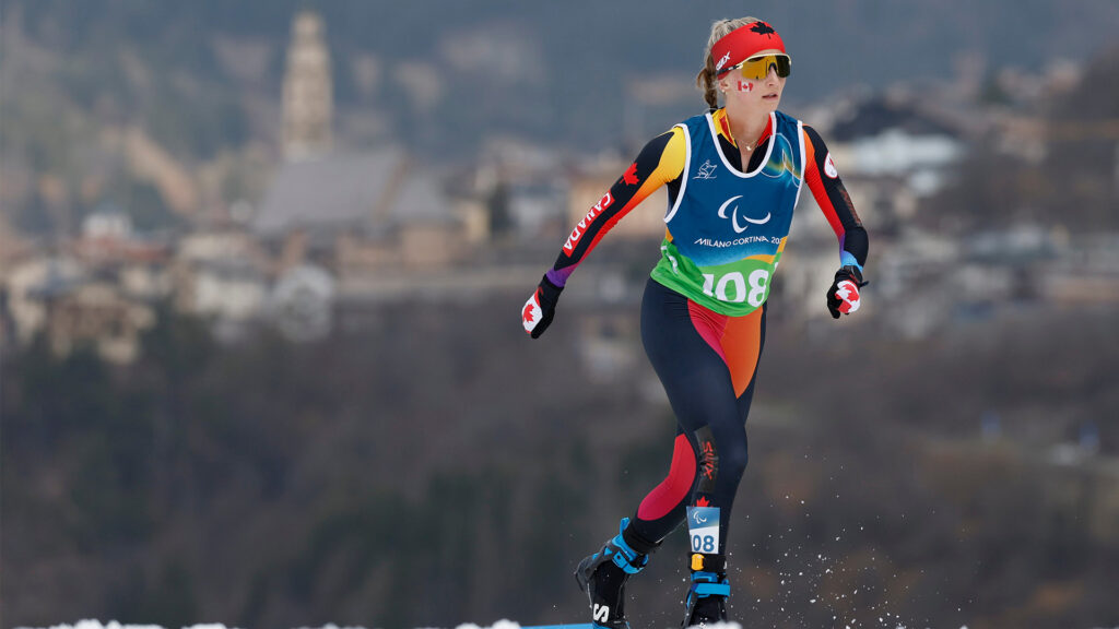 Woman skiing with hills and buildings in background
