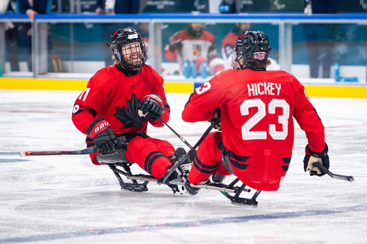 Two Canadian para ice hockey athletes interact on the ice