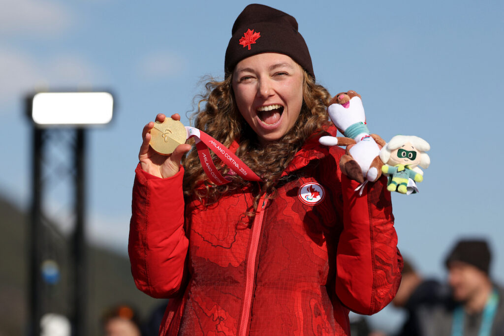 Woman holding gold medal and toy