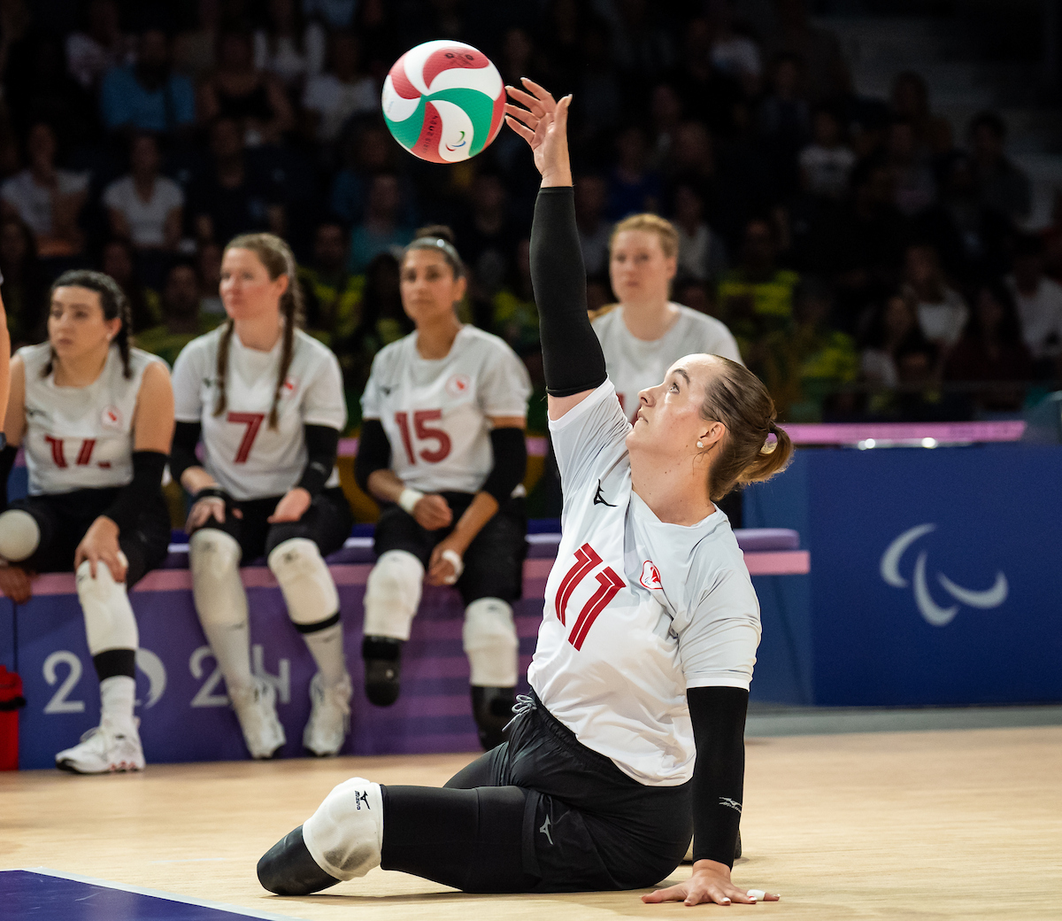 Sitting volleyball player serving during a game